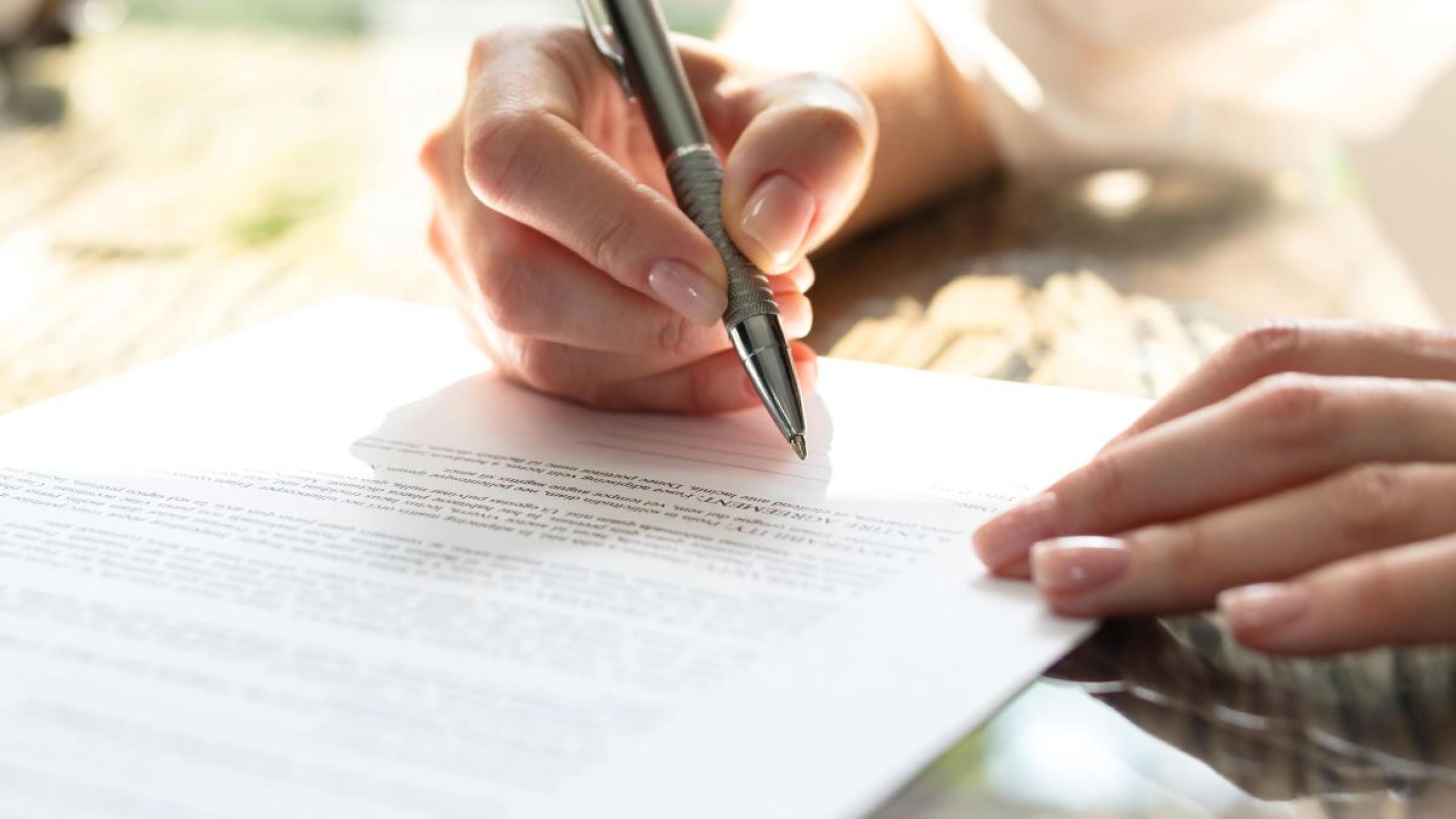 Close-up: handtekening zetten op contract.