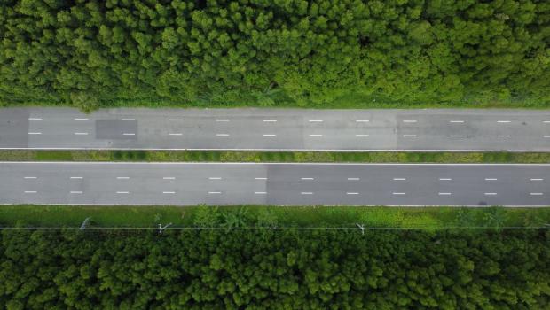 Droneshot van twee wegen in groen landschap.